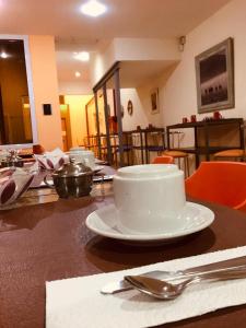 una mesa con un plato blanco en una mesa en Eco Plaza Hotel en Salta