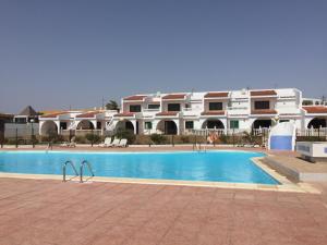 a swimming pool in front of a large building at Costa Antigua II in Costa de Antigua