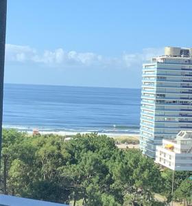 Blick auf das Meer und ein hohes Gebäude in der Unterkunft Torre One 2 Vista al Mar a metros de la playa in Punta del Este