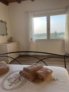 ein Schlafzimmer mit einem Bett mit zwei Handtüchern darauf in der Unterkunft Villa Flora di Capriata d'orba in Predosa