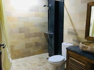 La salle de bains est pourvue d'une douche, de toilettes et d'un lavabo. dans l'établissement Ayu Bisma Homestay, à Ubud