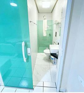 a bathroom with a glass shower and a toilet at Mon Chéri - Pousada Exclusive in Japaratinga