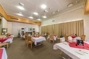 a restaurant with white tables and chairs and red tablecloths at Capella Coach Inn in Capella