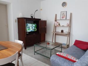 uma sala de estar com um sofá e uma televisão em Bompastor em Bompas