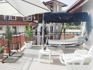 a patio with two chairs and a hammock and an umbrella at La terrace Sea view in Sveti Vlas +42 photos