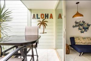 ein Esszimmer mit einem Tisch und einem blauen Stuhl in der Unterkunft DOWNTOWN LOCATION! Hawaiian Theme Condo with Hot Tub, Pool & Beach in Kailua-Kona