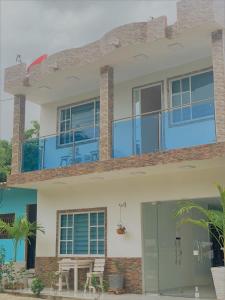 a house with blue windows and a patio at Buritaca House in Buritaca