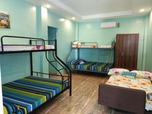 a room with two bunk beds and a couch at Azulea Lodging House Oslob in Oslob