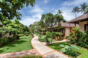 a walkway through a garden with trees and plants at Bao Quynh Bungalow in Mui Ne