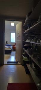 une chambre avec une porte s'ouvrant sur une chambre avec un réfrigérateur. dans l'établissement Simple private bedroom in a former Finnish School at the countryside, à Hyrsylä