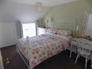 a bedroom with a bed and a table and a window at Widows Row Cottage in Newcastle