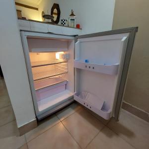 an empty refrigerator with its door open in a kitchen at El apartamento de Teddy in San Miguel de Tucumán