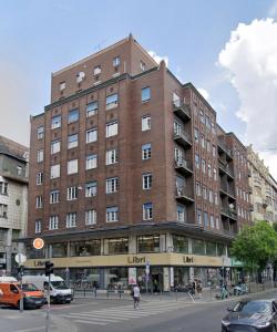 un gran edificio de ladrillo en una calle de la ciudad con coches en Astoria Downtown Superior, en Budapest