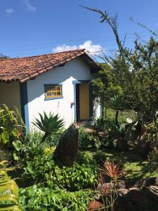 ein Haus mit Garten davor in der Unterkunft Chalés Vista das Montanhas in Lavras Novas