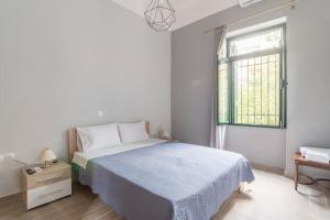 a white bedroom with a bed and a window at Athens Kerameikos Neoclassical House in Athens