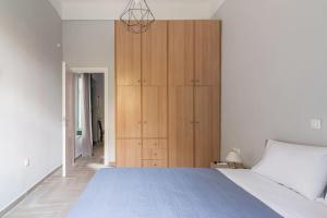 a bedroom with a large bed and a wooden cabinet at Athens Kerameikos Neoclassical House in Athens