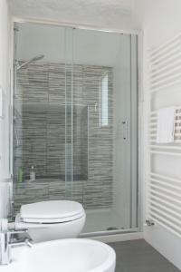 a bathroom with a toilet and a glass shower at 2 Rooms next to a market and Piazza Santa Croce - HomeUnity in Florence