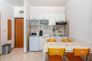 a kitchen with a table and yellow chairs in a room at Apartment Igor in Ičići