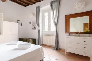 a bedroom with a bed and a dresser and a window at 2 Rooms next to a market and Piazza Santa Croce - HomeUnity in Florence