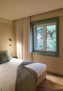 ein Schlafzimmer mit einem großen Bett und einem Fenster in der Unterkunft Oporto CoLiving Circunvalação 13250 in Porto