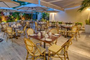 un restaurante con mesas de madera, sillas y sombrillas en Casa Nicole Boutique Hotel en Puerto Vallarta