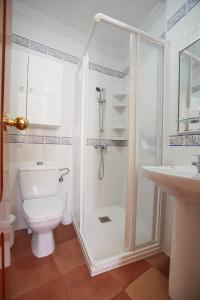 uma casa de banho com um chuveiro, um WC e um lavatório. em Hostal Azul em La Antilla