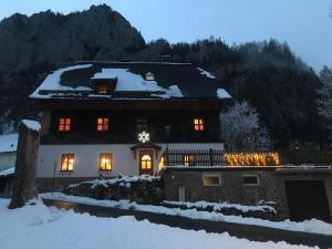 ein Haus mit Weihnachtslichtern im Schnee in der Unterkunft Weichselboden, Alte Schule in Weichselboden