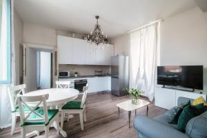 een keuken en een woonkamer met een tafel en stoelen bij Glamour - by MyHomeInComo in Como