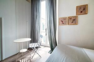 Schlafzimmer mit einem Bett, einem Tisch und einem Fenster in der Unterkunft Glamour - by MyHomeInComo in Como