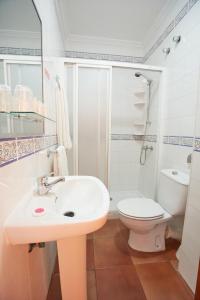 a white bathroom with a sink and a toilet at Hostal Azul in La Antilla +28 photos