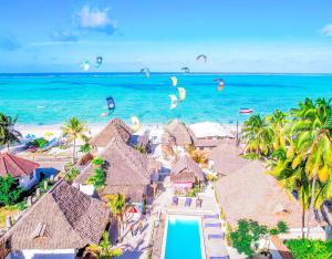 an aerial view of a resort with kites flying over the ocean at Ananda Beach Hotel in Paje