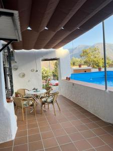 une terrasse avec une table et des chaises ainsi qu'une piscine dans l'établissement Huerta La Niña Arenas, à Órgiva