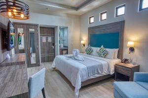 une chambre avec un grand lit et une tête de lit bleue dans l'établissement Casa Nicole Boutique Hotel, à Puerto Vallarta