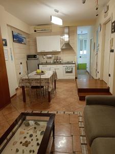 a living room with a table and a kitchen at Domus Cornelia in Naples