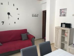 uma sala de estar com um sofá vermelho e algumas cadeiras em Appartamento 60 mq a 800 mt dalla spiaggia em Capaci