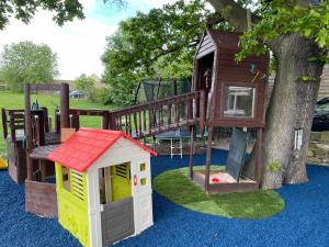 a playground with a play house and a tree at Brand new purpose built annex :- The Stables in Halifax