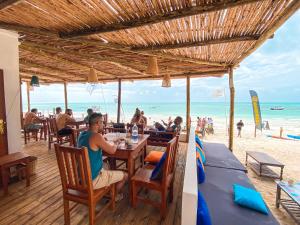 a person sitting at a table on the beach at Ananda Beach Hotel in Paje