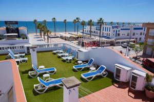 a group of lounge chairs and the beach at Hostal Azul in La Antilla