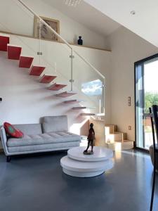 a living room with a couch and a staircase at Gîte de charme 5 étoiles pour couple avec sauna et jacuzzi extérieurs privatifs in Peaugres