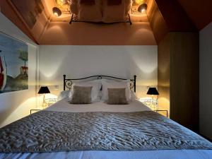 1 dormitorio con 1 cama grande y 2 lámparas en Gîte de charme 5 étoiles pour couple avec sauna et jacuzzi extérieurs privatifs en Peaugres