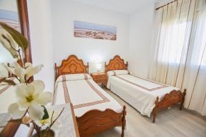- une chambre avec 2 lits et un vase de fleurs dans l'établissement VistAzul 401, à La Antilla