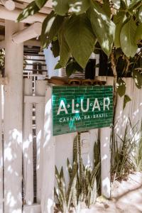 una señal de aluararmaarmaarma barleague en una valla en Pousada Aluar, en Caraíva