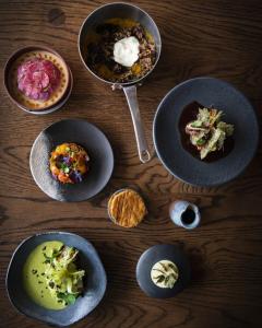 una mesa de madera con platos de comida. en Tintswalo Atlantic en Hout Bay