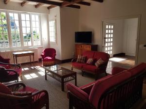 a living room with red chairs and a tv at Villa sur la corniche vue mer in Concarneau
