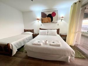 a bedroom with two beds with towels on them at Hosteria Iloca in Iloca
