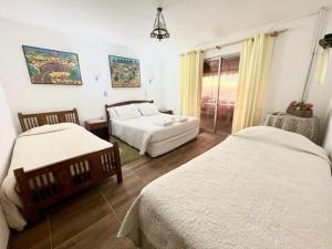 Habitación de hotel con 2 camas y ventana en Hosteria Iloca en Iloca