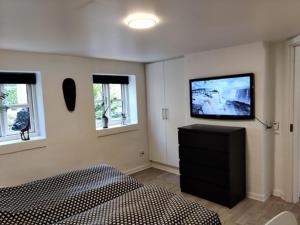 um quarto com uma cama e uma televisão na parede em Værelser i midtbyen em Herning