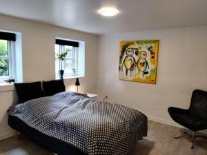 - une chambre avec un lit et une peinture murale dans l'établissement Værelser i midtbyen, à Herning