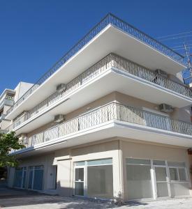 un edificio bianco con balcone sopra di Διαμερίσματα στο Δυτικό Μοσχάτο a Pireo