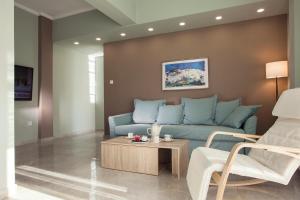 a living room with a blue couch and a coffee table at Διαμερίσματα στο Δυτικό Μοσχάτο in Piraeus